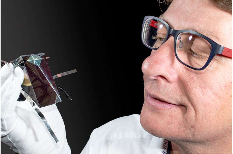 Mark Keevers tiene in mano la mini cella solare university of south wales Credit: Rob Largent/UNSW