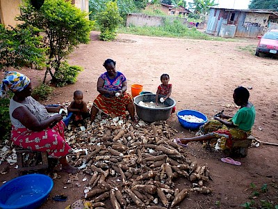 Donne africane mentre sbucciano i tuberi della tapioca