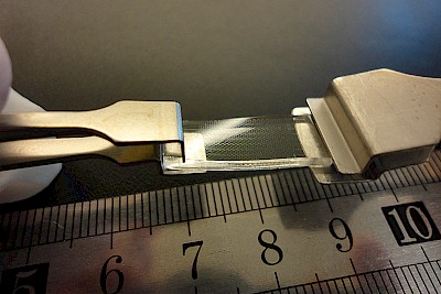 Il nuovo materiale prodotto dal team del prof. Juejun Hu può essere ripetutamente allungato senza perdere le sue proprietà ottiche. Credits: MIT, Cambridge, USA